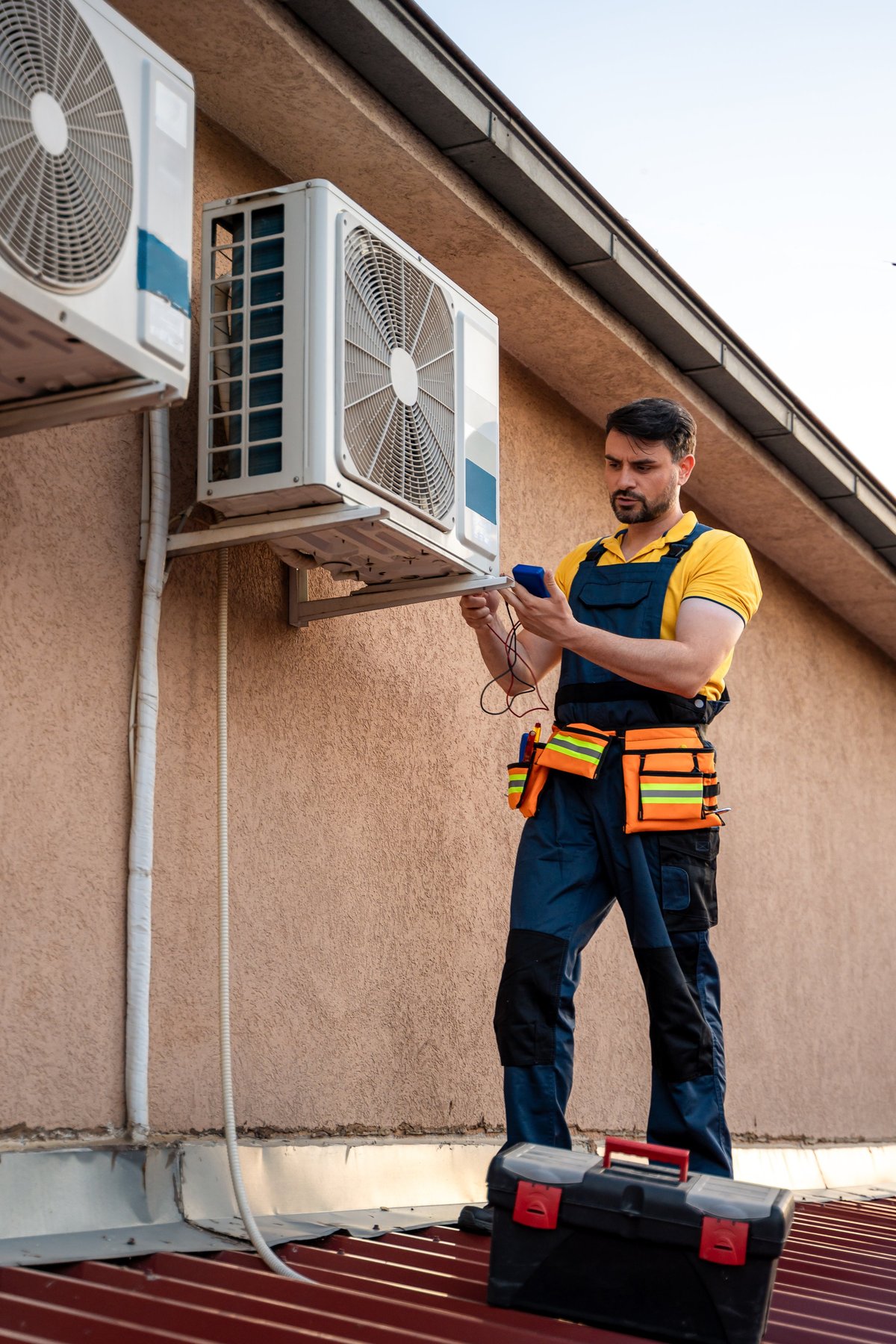 Technician inspecting units on a rooftop